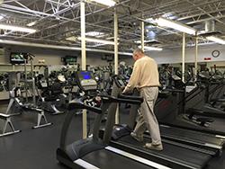 Senior walking on a treadmill at the Fitness Center.